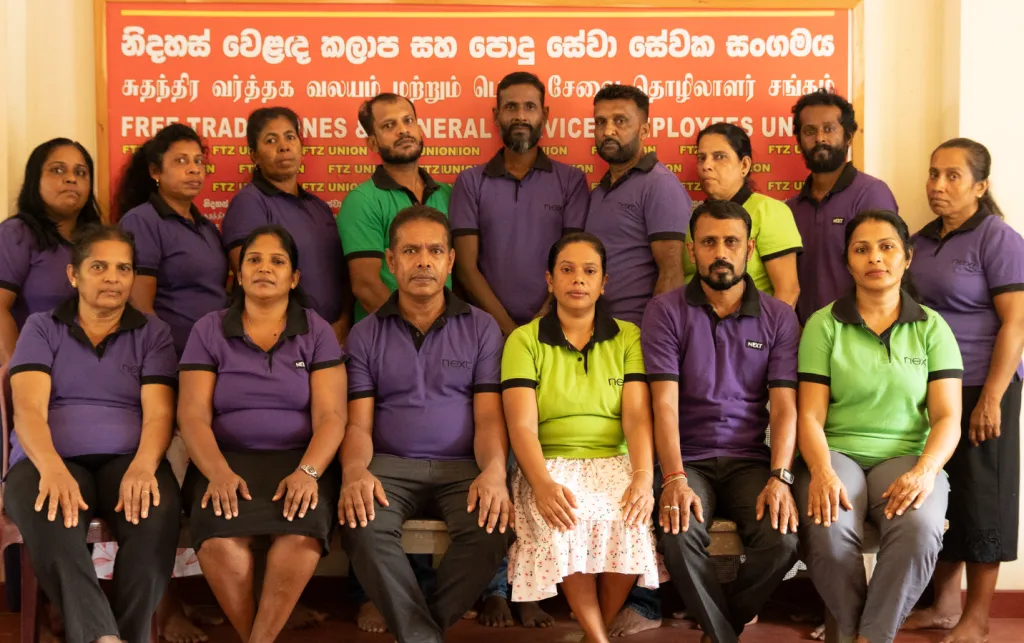 A group of people stand together and look at the camera