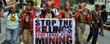 Kalikasan members march with signs saying "Mining plunder kills!" and "Stop the killings, stop large-scale mining". Photo: Kalikasan People's Network for the Environment.