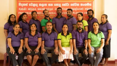 A group of people stand together and look at the camera